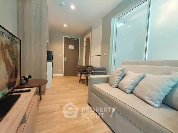 Modern living room with cozy sofa and flat-screen TV in a stylish apartment.