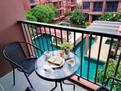 Charming balcony view overlooking lush garden and pool, perfect for relaxing mornings with coffee.