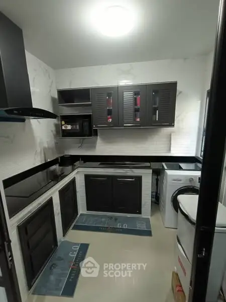 Modern kitchen with sleek black cabinets and built-in appliances