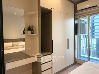 Modern bedroom with built-in wardrobe and balcony access in urban apartment.