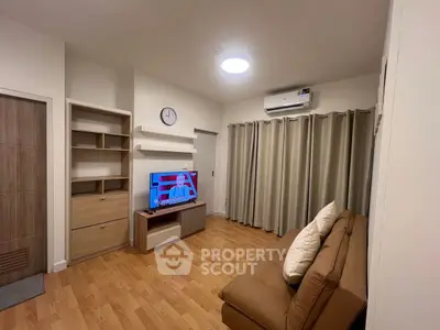Modern living room with wooden flooring, cozy sofa, and wall-mounted TV for a comfortable lifestyle.