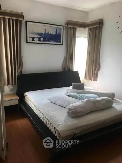 Cozy bedroom with modern bed and elegant curtains, perfect for relaxation.