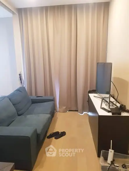 Cozy living room with blue sofa and TV, perfect for relaxation.