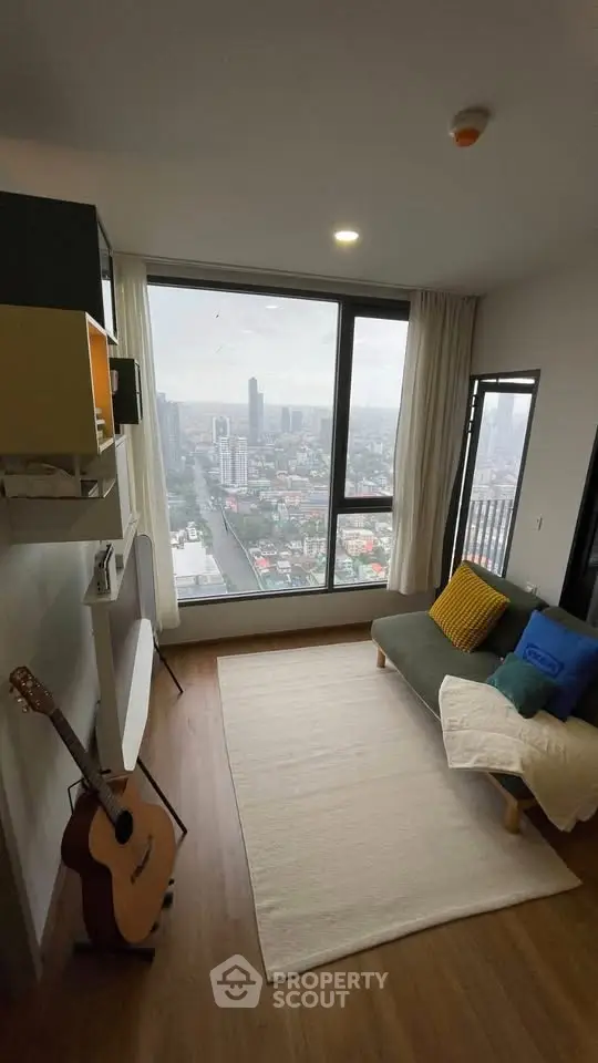 Modern living room with stunning city view, cozy seating, and stylish decor in high-rise apartment.