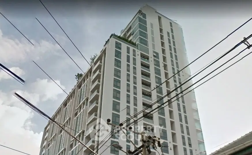 Modern high-rise building with sleek design and large windows in urban setting.