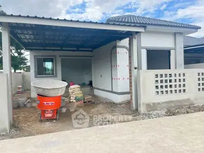 Modern house under construction with open garage and unfinished exterior.