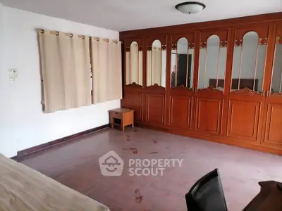 Spacious bedroom with elegant wooden wardrobes and natural light