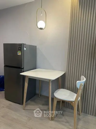 Modern kitchen corner with sleek fridge and minimalist dining set