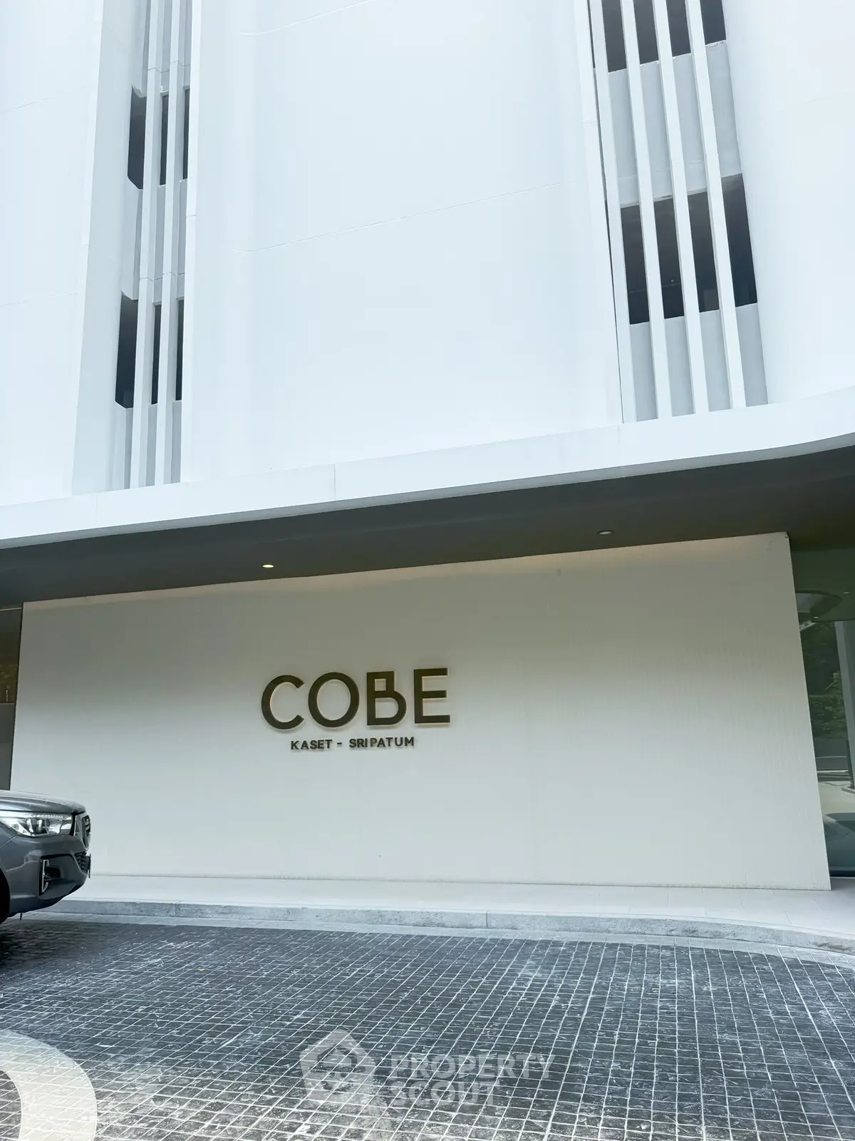 Modern building exterior with sleek design and prominent COBE signage, ideal for urban living.