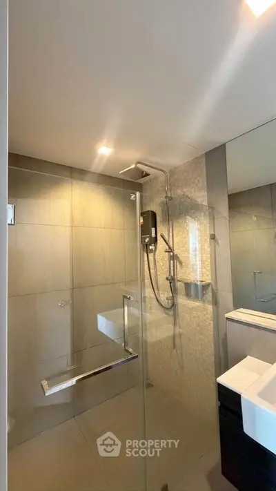 Modern bathroom with glass shower enclosure and sleek fixtures