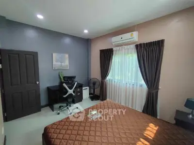 Modern bedroom with stylish decor and natural light, featuring a comfortable bed and workspace.