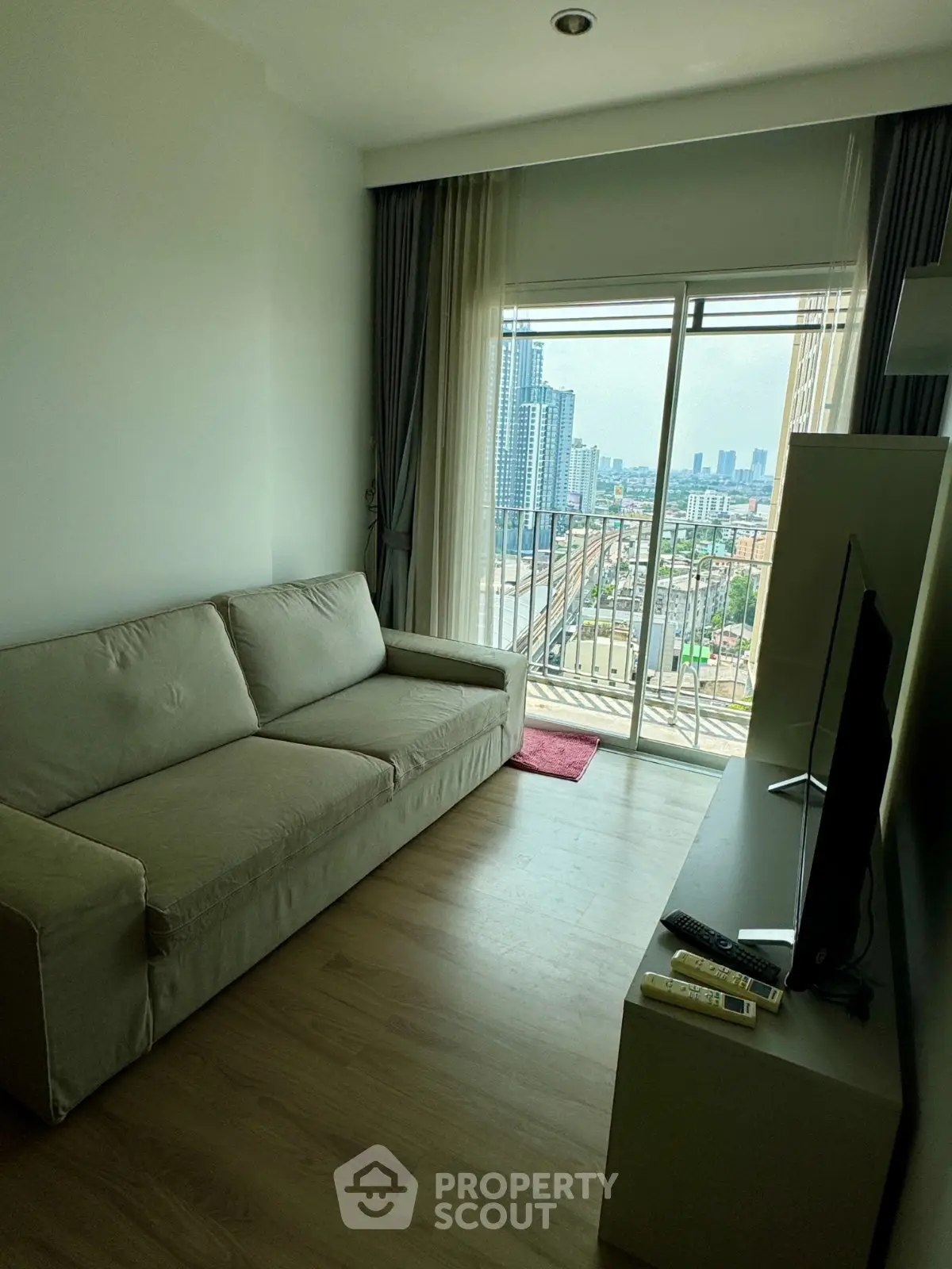 Modern living room with city view and cozy sofa in high-rise apartment
