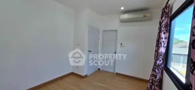 Bright empty room with wooden flooring and air conditioning, ideal for customization.