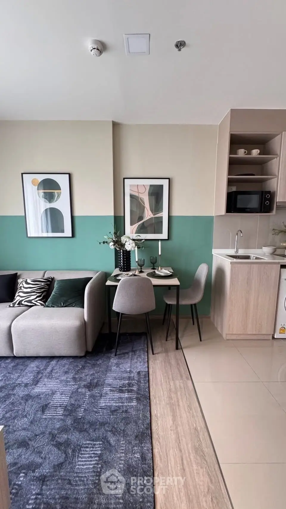 Modern open-plan living room with stylish decor and compact kitchen area.