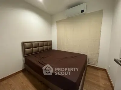 Cozy bedroom with air conditioning and wooden flooring, perfect for restful nights.