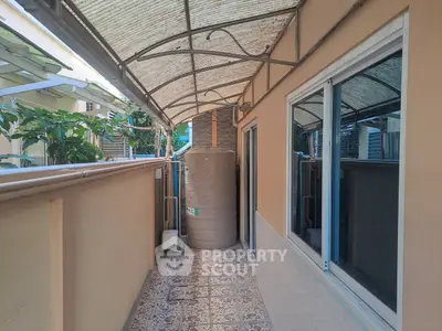 Narrow balcony with water tank and tiled flooring in a residential property