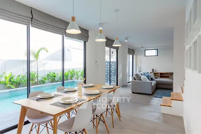 Modern open-plan living and dining area with pool view, featuring stylish furniture and ample natural light.
