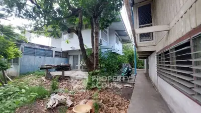 Charming fixer-upper property with lush greenery and potential for renovation in a serene neighborhood.