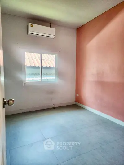 Cozy empty room with air conditioning and window view, perfect for customization.