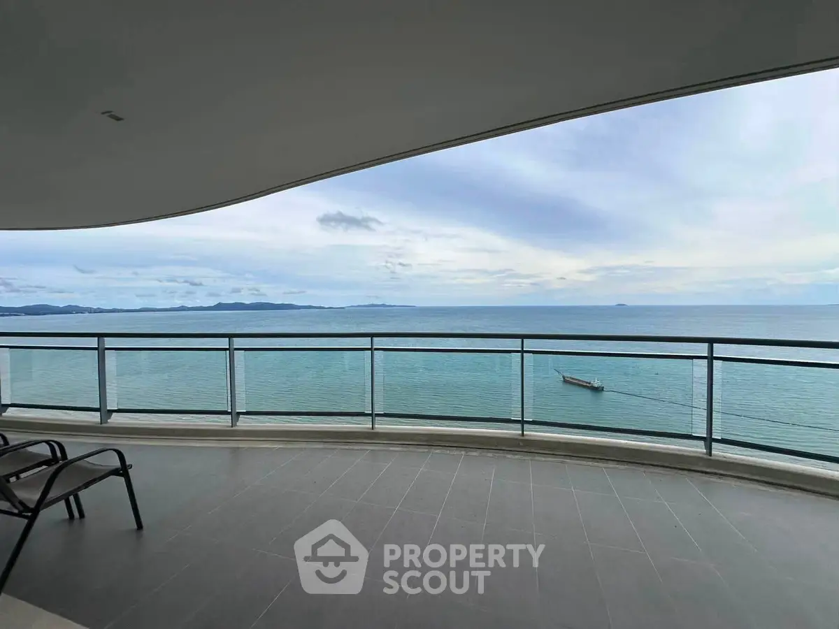 Stunning oceanfront balcony with panoramic sea views and modern glass railing.
