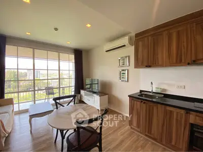 Charming open-plan living room with kitchen and balcony view