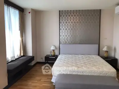 Spacious bedroom with elegant decor and natural light, featuring a comfortable bed and stylish furnishings.