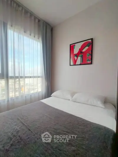 Cozy bedroom with large window and modern decor in a stylish apartment.