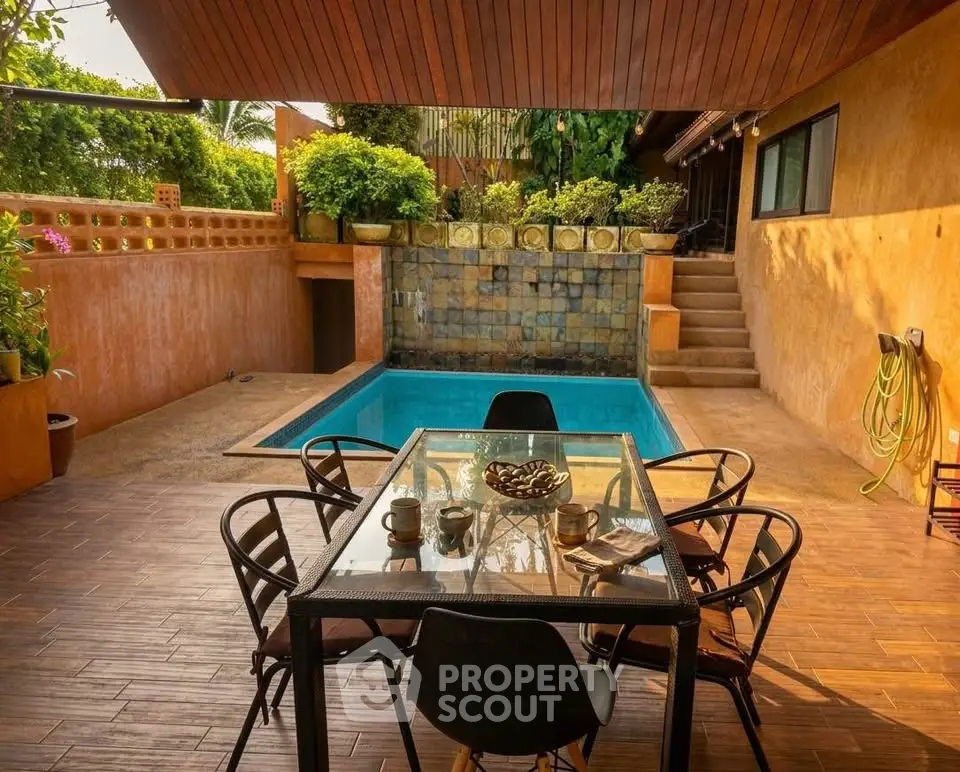Charming outdoor patio with pool and dining area, perfect for relaxation and entertaining.