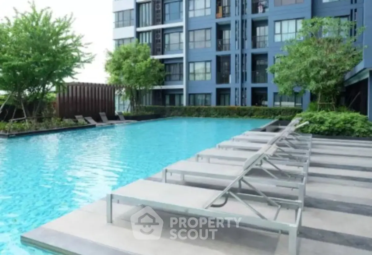 Luxurious apartment complex with a stunning outdoor pool and modern lounge chairs.