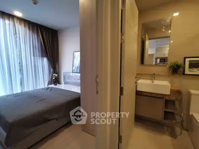 Modern bedroom with ensuite bathroom featuring sleek design and natural light.