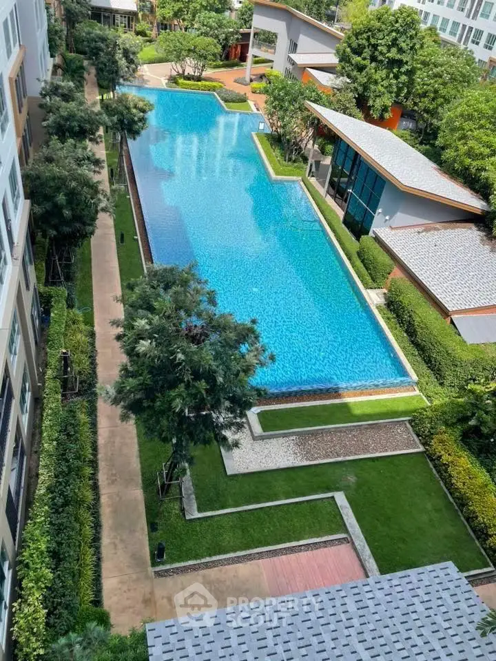 Luxurious residential complex with stunning pool and lush greenery view.