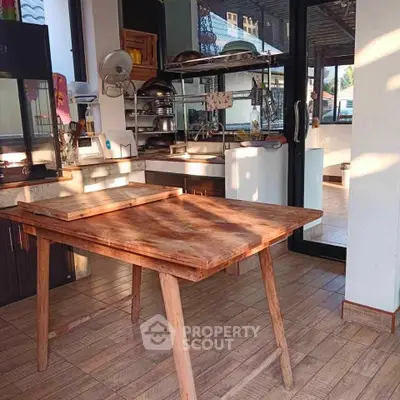 Charming kitchen with rustic wooden table and modern appliances, perfect for culinary enthusiasts.