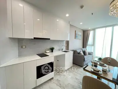 Modern open-layout kitchen with sleek white cabinets and cozy living area