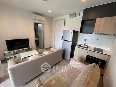 Modern living room with kitchenette and cozy seating area in a stylish apartment.