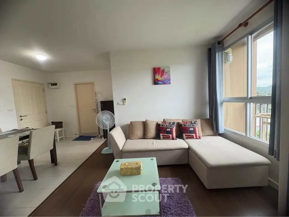Spacious living room with modern decor and large windows in a stylish apartment.