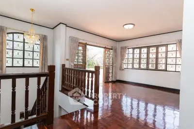 Spacious and bright living area with wooden flooring and large windows.