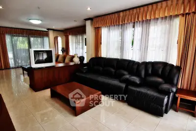 Spacious living room with elegant leather sofa and large windows for natural light.