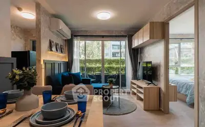 Modern open-plan living room with dining area and view of bedroom, featuring stylish decor and natural light.