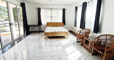 Spacious bedroom with elegant marble flooring and natural light