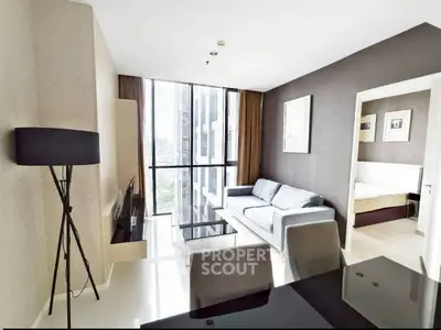 Modern living room with large windows and stylish furniture in a high-rise apartment.