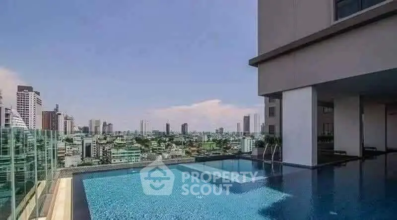 Luxurious rooftop pool with stunning city skyline view in modern high-rise building.