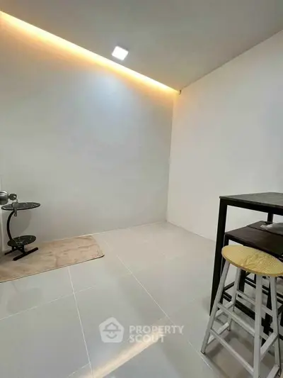 Minimalist interior with sleek tile flooring and modern lighting, perfect for a cozy living space.