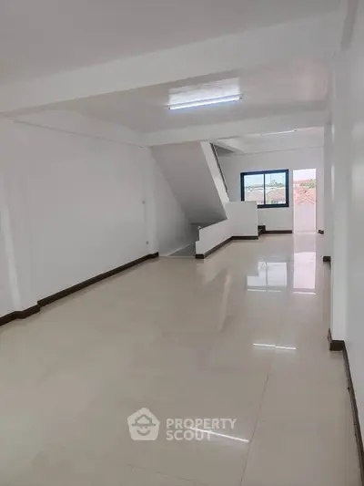 Spacious and bright open-plan living area with modern finishes and large window views.