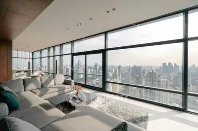 Luxurious living room with panoramic city views and modern furnishings.