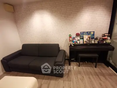 Cozy living room with dark sofa and decorative piano against brick wall