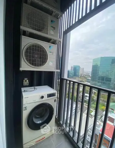 High-rise balcony with city view featuring washing machine and air conditioning units.