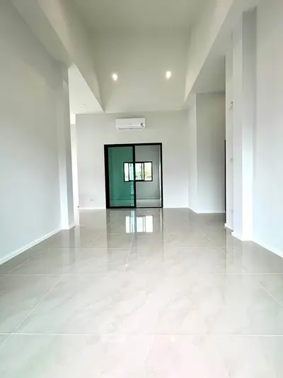 Spacious modern living room with high ceilings and sleek tile flooring.