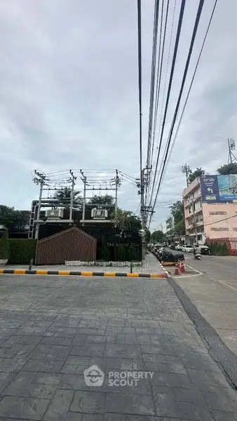 Street view with buildings and power lines, showcasing urban infrastructure and potential real estate opportunities.