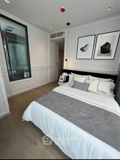 Luxurious modern bedroom with elegant decor and cozy ambiance, featuring stylish artwork and plush bedding.