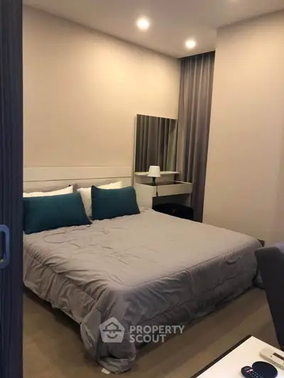 Cozy modern bedroom with stylish decor and comfortable bedding in a contemporary apartment.